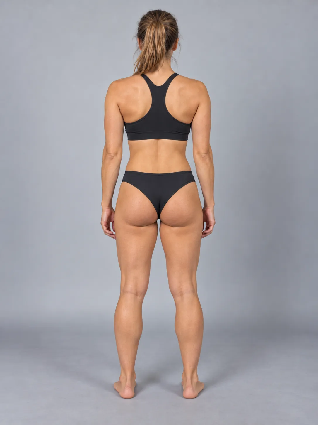 Example progress photo pose, back view: standing relaxed against a plain background